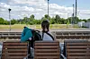 Eine junge Frau wartet bei Sommerwetter auf einen Zug. (Symbolbild)