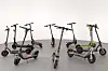 Mehrere ADAC-E-Scooter stehen im Studio auf grauem Boden.