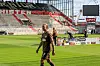 Jackson Irvine von FC St. Pauli geht im Millerntorstadion über den Rasen, im Hintergrund Stadionbühne und Werbebanden.