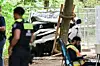 Beschädigtes Auto neben Baum, Polizisten und Einsatzhelfer am Unfallort.