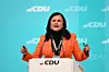 Rednerin am CDU-Pult vor türkisfarbenem Hintergrund mit CDU-Logos