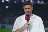 Simon Terodde spricht mit Mikrofon vor der Veltins-Arena in Gelsenkirchen.