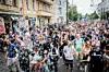 Menschenmenge mit Fahnen und Transparenten demonstriert auf einer Innenstadtstraße.