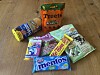 Bunte Süßigkeiten- und Snackpackungen auf einem Holzboden, darunter Mentos, Treets und Katjes.