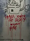 Schwarze Skizze und rote Graffiti mit Farbläufern auf einer hellen Fliesenwand.