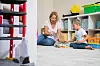 Oma und Enkel spielen auf dem Boden in einem Kinderzimmer in Berlin.