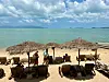 Urlauber am Strand von Bophut auf Koh Samui, Liegen unter Sonnenschirmen am Meer.