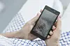 Frau hält ein Smartphone mit zerbrochenem Display in den Händen.