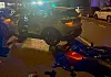 SUV und beschädigtes Motorrad an einer nächtlichen Unfallstelle, Blaulicht im Hintergrund.