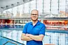 Junger Mann mit blauem Polohemd in einem Schwimmbad