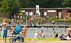 Menschen baden und sonnen sich am Naturbad Kiwittsmoor in Hamburg am Seeufer.