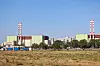 Kernkraftwerk MVM Paks in Ungarn mit Kühltürmen hinter trockenem Gelände und blauem Himmel