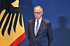 Bundeskanzler Friedrich Merz steht vor der deutschen Flagge beim Termin im Amtssitz am Spreebogen.