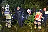 Rettungskräfte und Polizei durchsuchen nachts ein dichtes Gebüsch mit Taschenlampen.