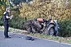 Eine Polizistin steht neben den Überresten des Unfallwagens. Das Auto war auf der Landstraße nahe Bremen gegen vier Straßenbäume gefahren und in zwei Teile zerbrochen.