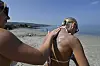 Am Strand bei Carnfunnock wird einer Frau Sonnencreme auf den Rücken aufgetragen.