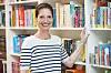 Julia Bielenberg lächelt in den neu bezogenen Räumen der Verlagsgruppe Oetinger vor einem Bücherregal.