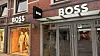 Boss-Geschäft mit Schaufenster, Eingang und leuchtender Beschilderung an einer Backsteinfassade.