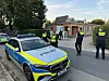 Polizeikräfte vor einem Wohnhaus, Streifenwagen mit Blaulicht im Vordergrund.