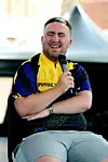 Luke Littler sitzt mit Mikrofon bei einer Fragerunde in Warrington.