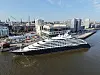 Scenic Eclipse 2 im Hafen vor moderner Uferkulisse.