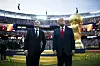 Donald Trump und Gianni Infantino stehen auf dem Rasen vor dem WM-Pokal im MetLife Stadium.