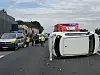 Auf der A23 bei Hamburg-Nordwest liegt ein weißer Toyota auf der Seite, Rettungskräfte sichern die Unfallstelle.
