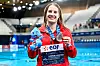 Michelle Luisa Heimberg hält im Schwimmstadion ihre Silbermedaille und eine blaue Plüschfigur.