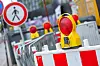Rote-weiße Baustellenabsperrung mit Warnleuchten an einer gesperrten Straße in Hamburg.