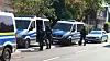 Polizeiwagen und Einsatzkräfte stehen in einer Wohnstraße an der Straße.