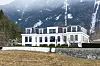 Villa N in Innsbruck-Igls vor verschneiten Bergen.