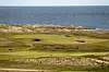 Golfplatz Budersand in Hörnum auf Sylt mit Dünen und Wattenmeer im Hintergrund.