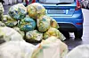 Müllsäcke liegen in Mailand auf Gehweg und Straße vor einem geparkten Auto.