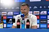 Edin Džeko sitzt bei der Vorstellung von FC Schalke 04 in der Veltins-Arena vor Mikrofon und Sponsorenwand.