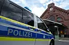 Polizeiauto vor dem Bahnhof Harburg mit Backsteinfassade im Hintergrund.