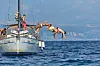 Mehrere Urlauber springen gleichzeitig von einem Segelboot ins Meer vor Opatija.