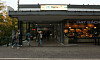Eingang zum U-Bahnhof Berne in Hamburg, mehrere Passanten vor dem Glasbau.