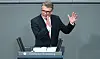 Thomas Bareiß spricht am Rednerpult im Bundestag und hebt die Hand.