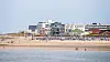 Strand auf Norderney mit Badegästen, Dünen und Gebäuden im Hintergrund nach Sperrung.