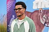 Malik Tillman lächelt bei der Premiere von „The Hawk“ vor einer bunten Wand mit Tiermotiv in Los Angeles.