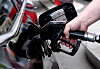 Mann tankt ein Auto an der Zapfsäule einer Tankstelle.