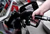 Mann tankt ein Auto an der Zapfsäule einer Tankstelle.