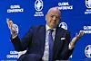 Gianni Infantino spricht bei der Milken-Konferenz vor blauem Logo-Hintergrund und hebt beide Hände.