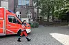 Einsatzkraft vor rotem Rettungswagen bei Brand eines Kühlschranks an der Kita Sternipark in Harburg.