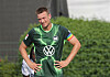 Hauke Wahl im grünen VfL-Wolfsburg-Trikot, Hände in die Hüften, auf dem Trainingsplatz.