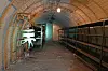 Innenraum eines langen Bunkers mit alter Lüfteranlage, Regalen und gewölbter Decke in Hamburg.