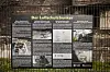 Informationstafel zum Luftschutzbunker der Holborn-Raffinerie hinter einem Zaun in Harburg