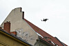 Drohne über Berliner Dächern am hellen Himmel.