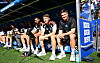 Richard Krohn, Loic Favé und Merlin Polzin sitzen beim HSV-Testspiel an der Seitenlinie.