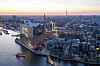 Elbphilharmonie bei Sonnenuntergang über Hamburg mit beleuchteten Fenstern und Blick auf Hafen und Stadt.